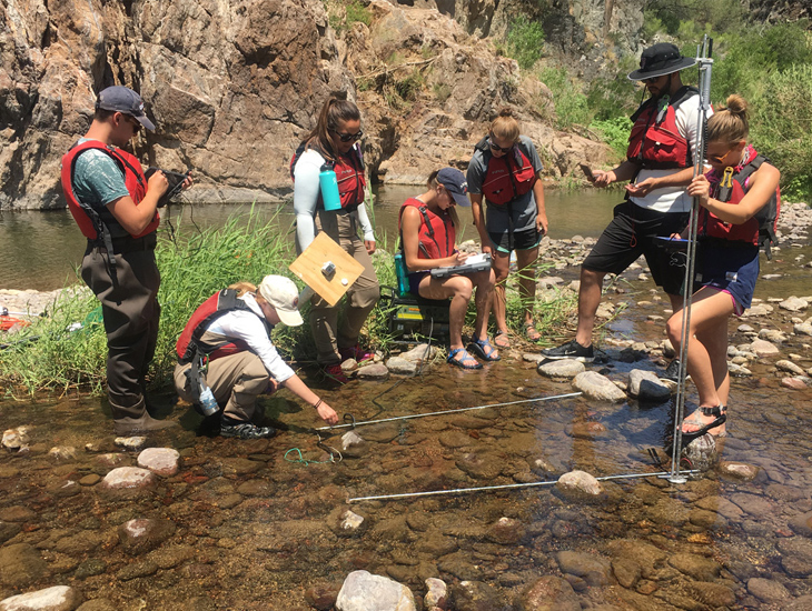 students with instructor inspect a river