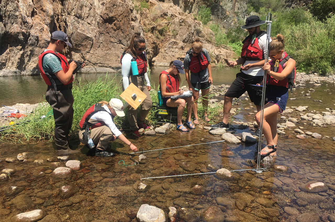 students with instructor inspect a river